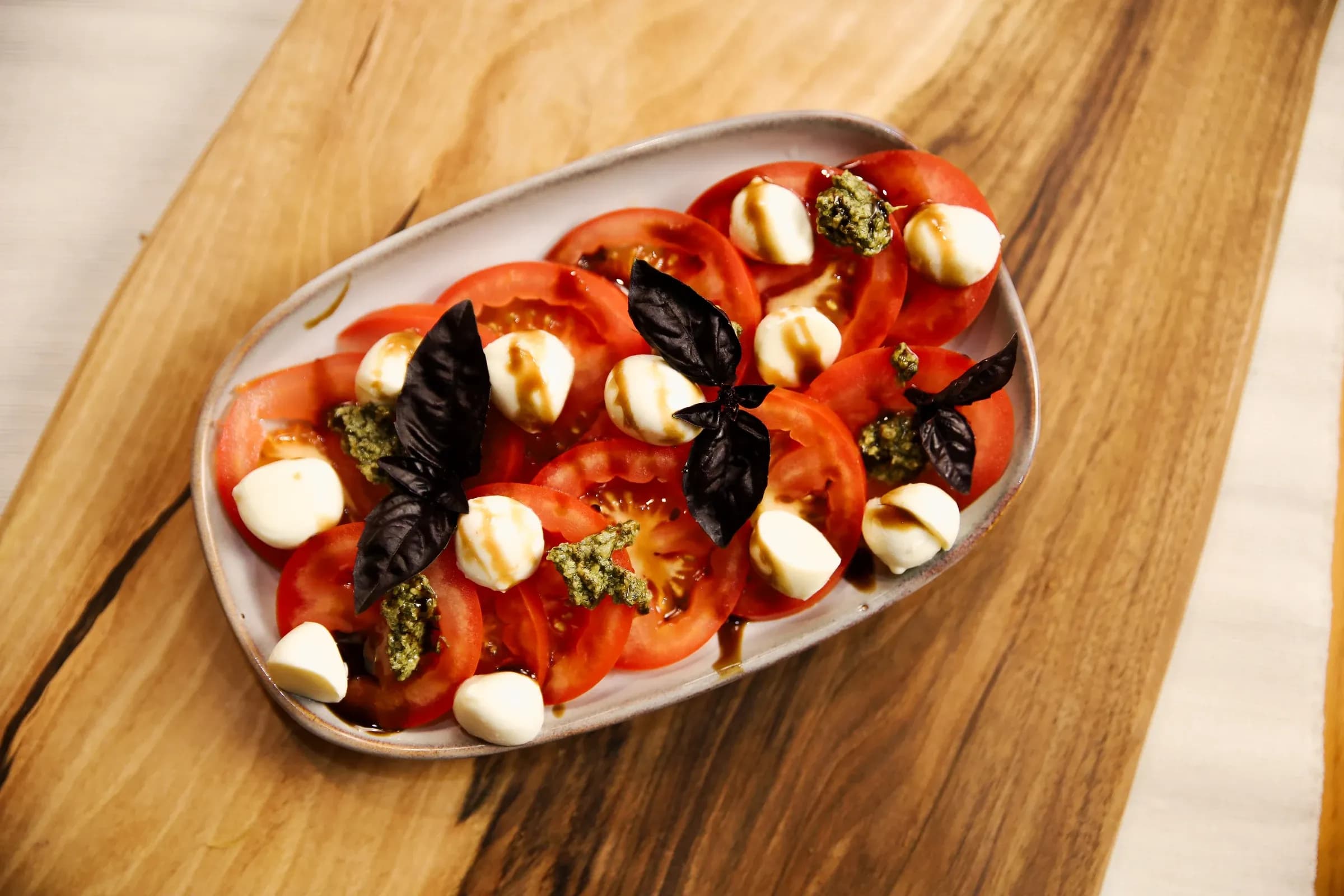 Mocarellas un tomātu kārtojums ar pesto un baziliku